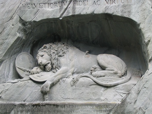 ルツェルンのライオン像。スイス人の忠誠心と勇気、フルール・ド・リス、背に矢が刺さって負傷したライオンのため、フランス王ルイ16世への忠誠を尽くしてテュイルリー宮殿で命を落としたスイス人への追憶をこめて。1819年、デンマーク人彫刻家ベルテル・トルヴァルドセン、彼らの犠牲を記念してこの記念碑を刻む。